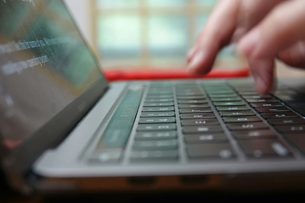 Close-up of a person typing on a laptop keyboard. 