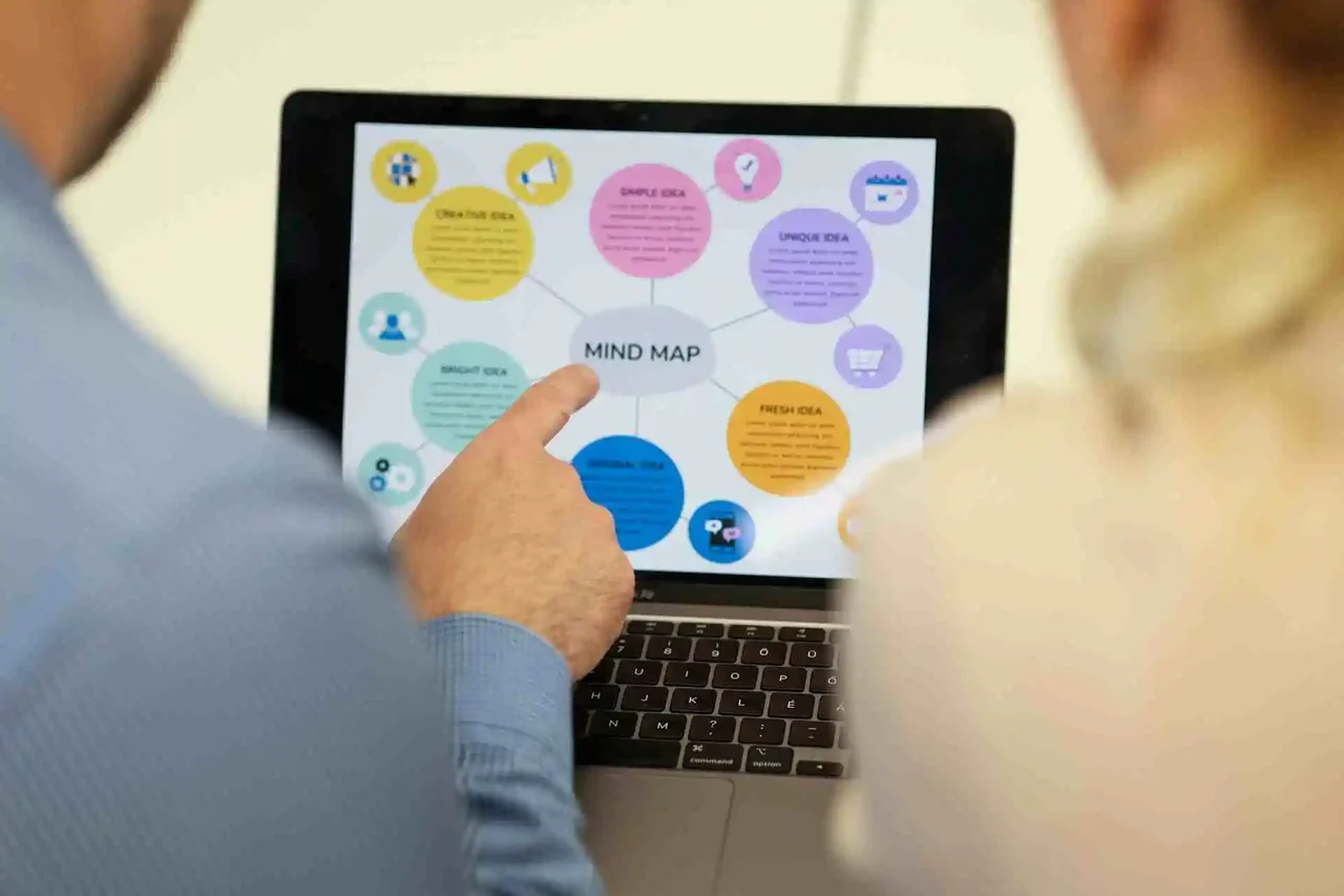  Person pointing to a digital mind map on a laptop screen